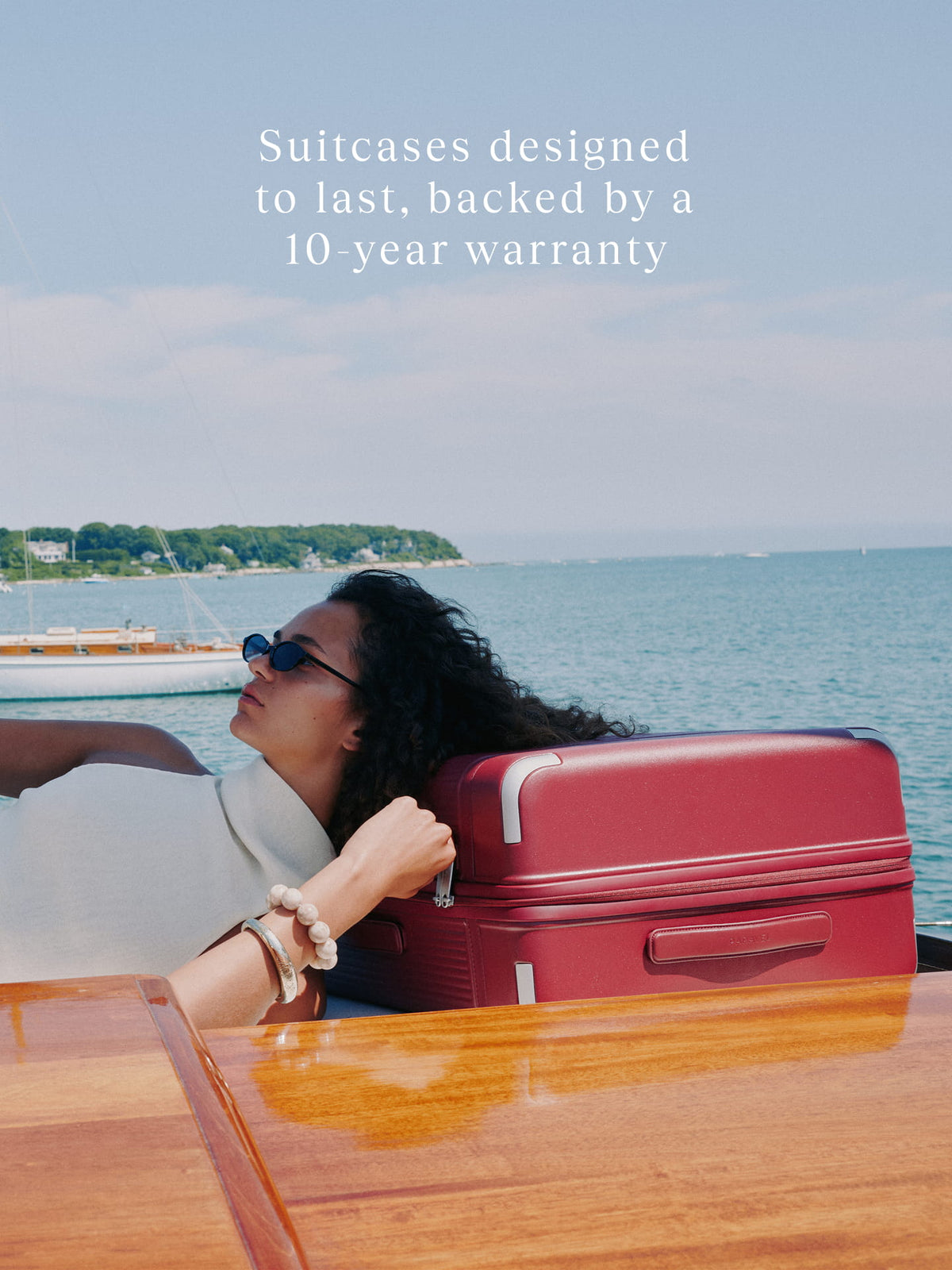 a woman lying on a boat with a suitcase