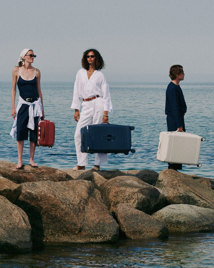 a group of people with luggage on rocks