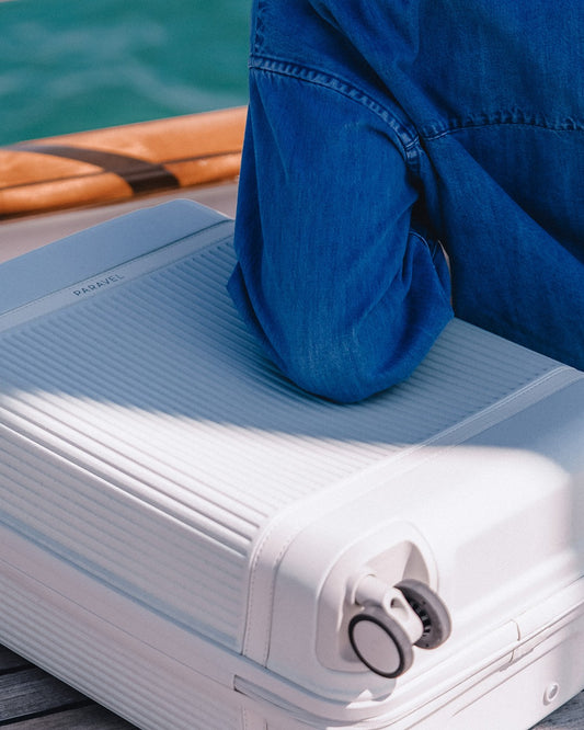 a person sitting on a white suitcase