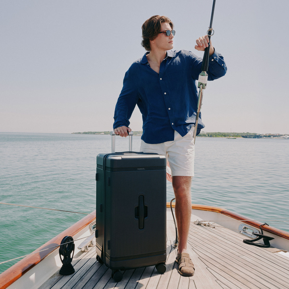 a man standing on a boat with a suitcase