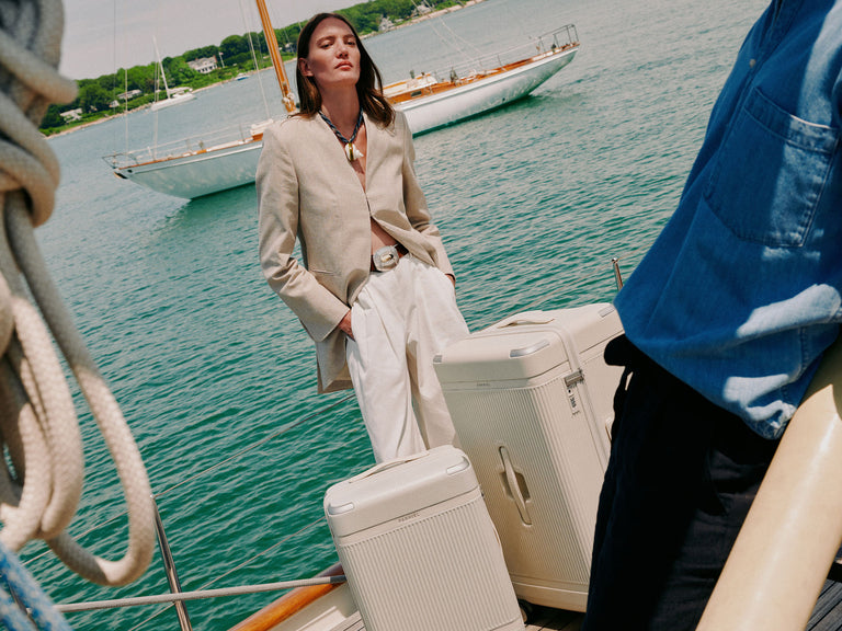 a woman standing on a boat with luggage
