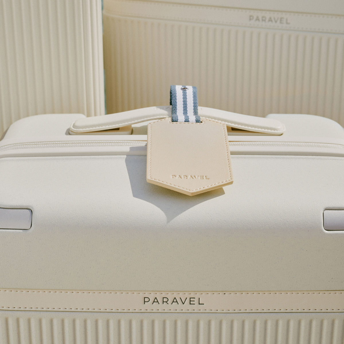 a white suitcase with a tag on it