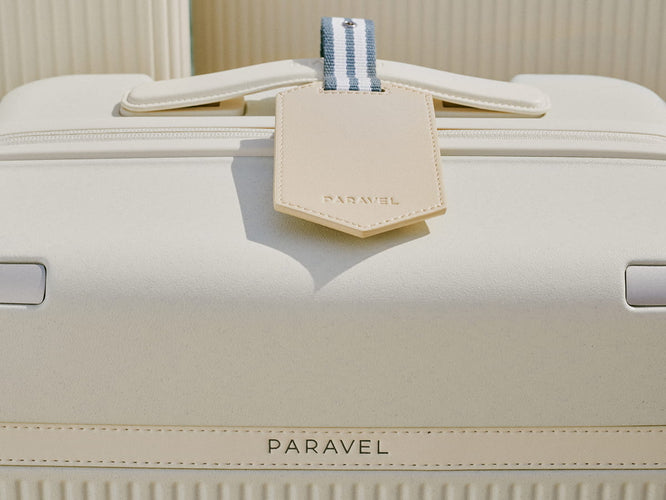 a white suitcase with a tag on it