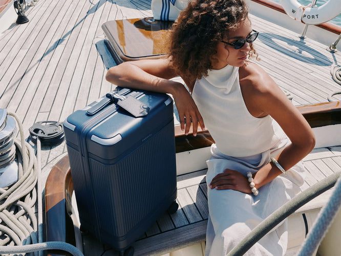 a woman sitting on a boat with a suitcase