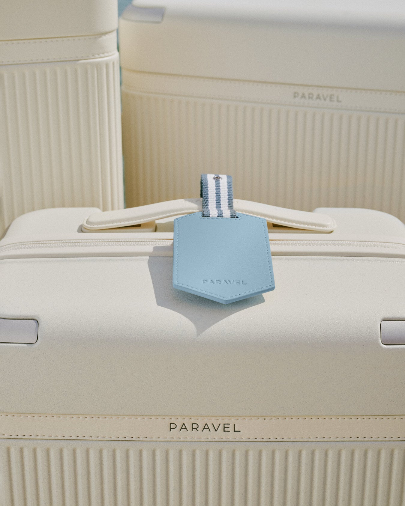 a white suitcase with a blue tag on it