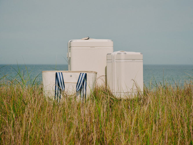 a group of white suitcases in a grassy area